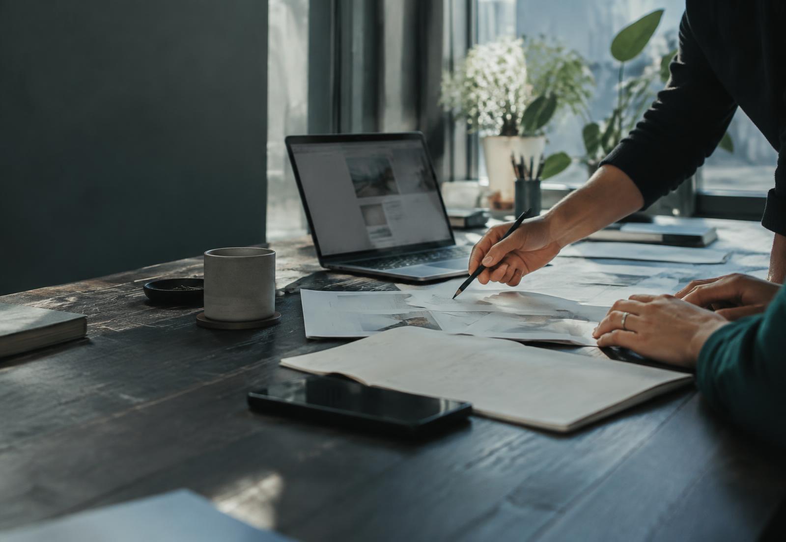 Hands working through campaign ideas and documents at a desk
